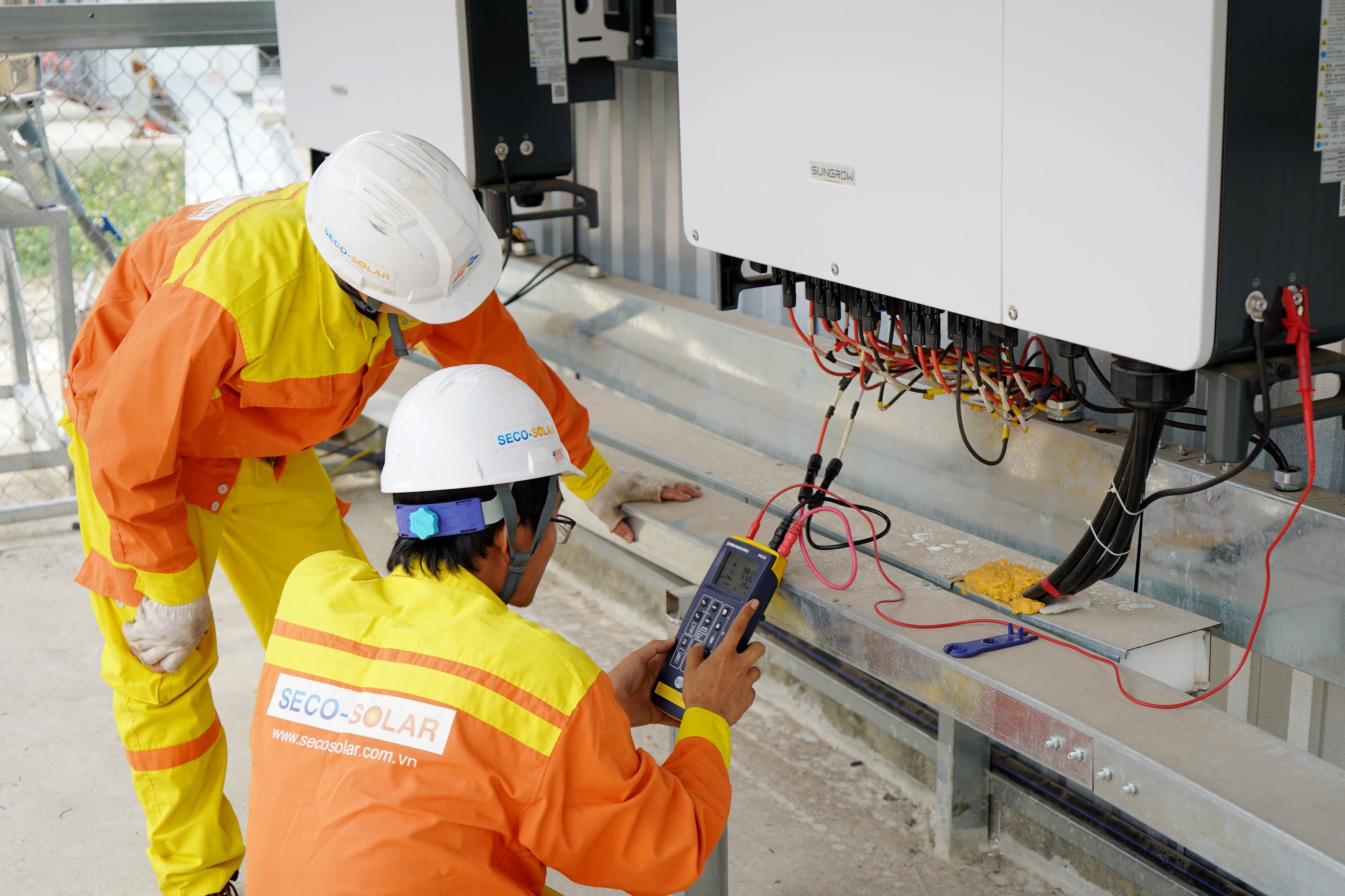 An install crew fitting panels on a roof
